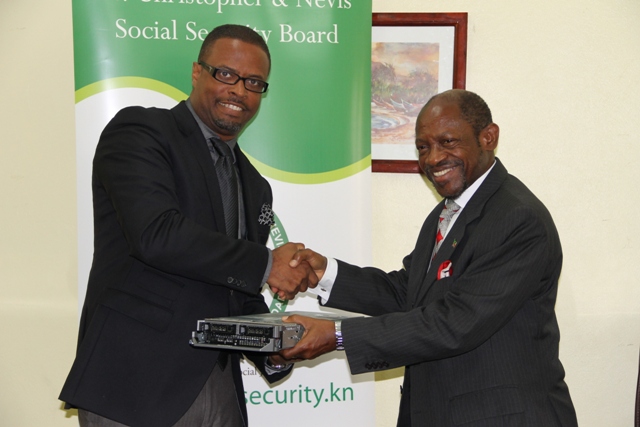 Acting Premier of Nevis Hon. Mark. Brantley (left) receives computer equipment for use by the Ministry of Finance from Prime Minister of St. Kitts and Nevis the Rt. Hon. Dr. Denzil Douglas through the St. Christopher and Nevis Social Security Board at a handing over ceremony at the Ministry of Finance conference room on May 22, 2014